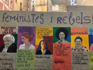 Eine Wand mit einem Graffiti, das historische Frauen und Zitate von ihnen zeigt