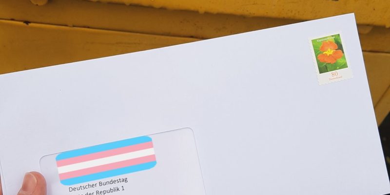Briefe an den Bundestag, frankiert vor Briefkasten mit TransPrideFlag